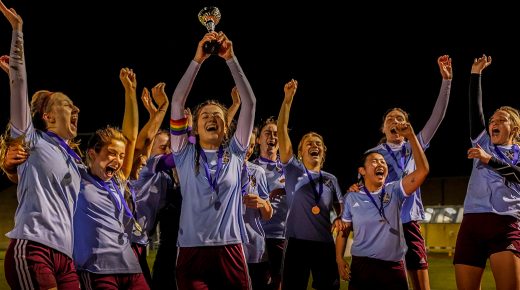 The women's football team celebrate together as they receive the Cuppers trophy.